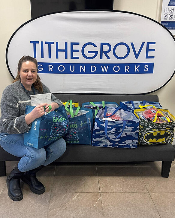 woman on bench with bags to donate to charity